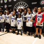 Young basketball players lined up in Clippers jerseys at a sports event.