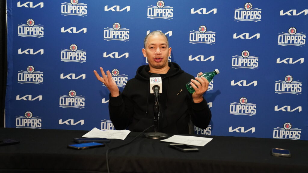 A man speaking at a press conference with a Clippers backdrop.