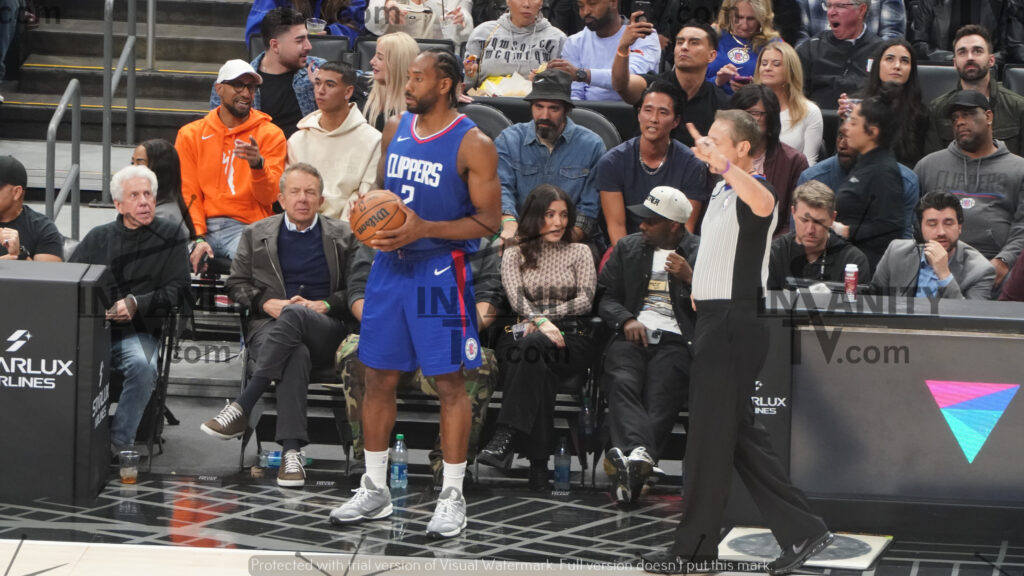 NBA player in blue jersey holding basketball on court.
