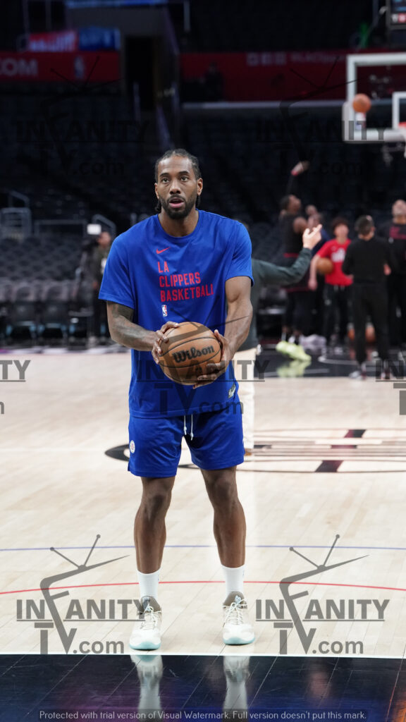Basketball player practicing shots on court before a game.