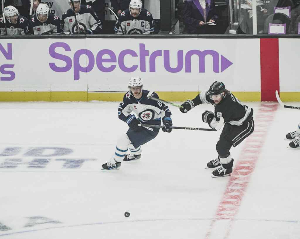 Two hockey players compete fiercely on the ice during a game.