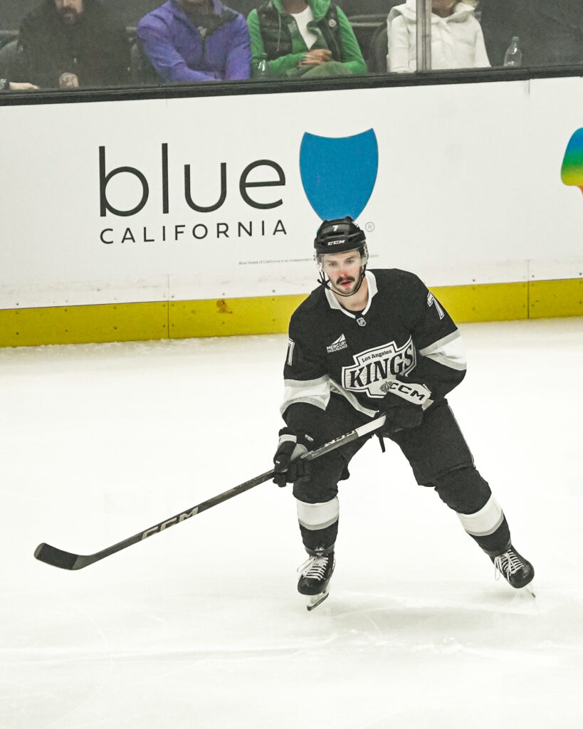 Ice hockey player in action on the rink wearing a black uniform.