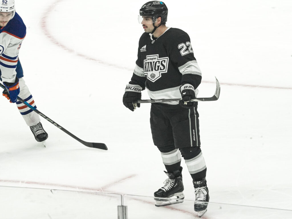 Ice hockey player in black Kings uniform on the rink.