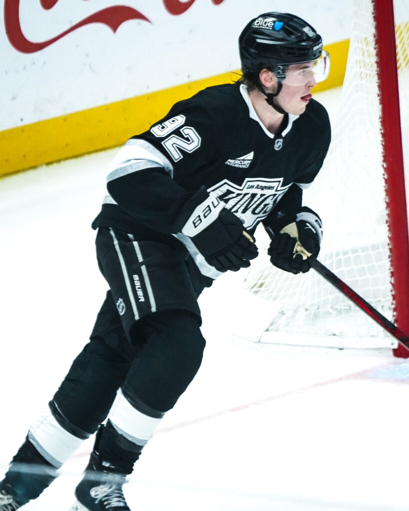 Hockey player in black jersey skating on the ice during a game.