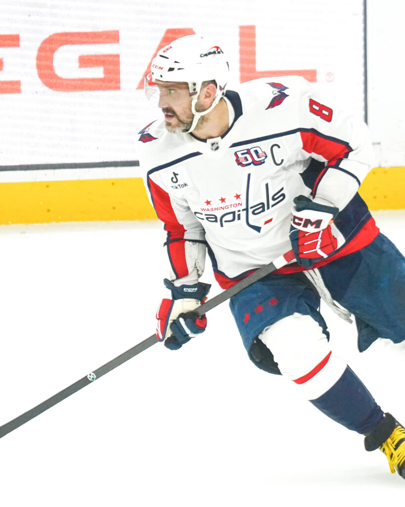 Hockey player in white jersey skating during a game.