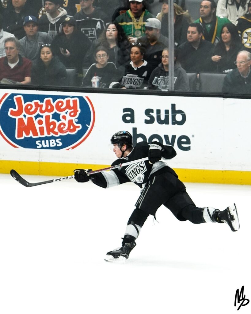Hockey player taking a powerful slapshot on the ice.