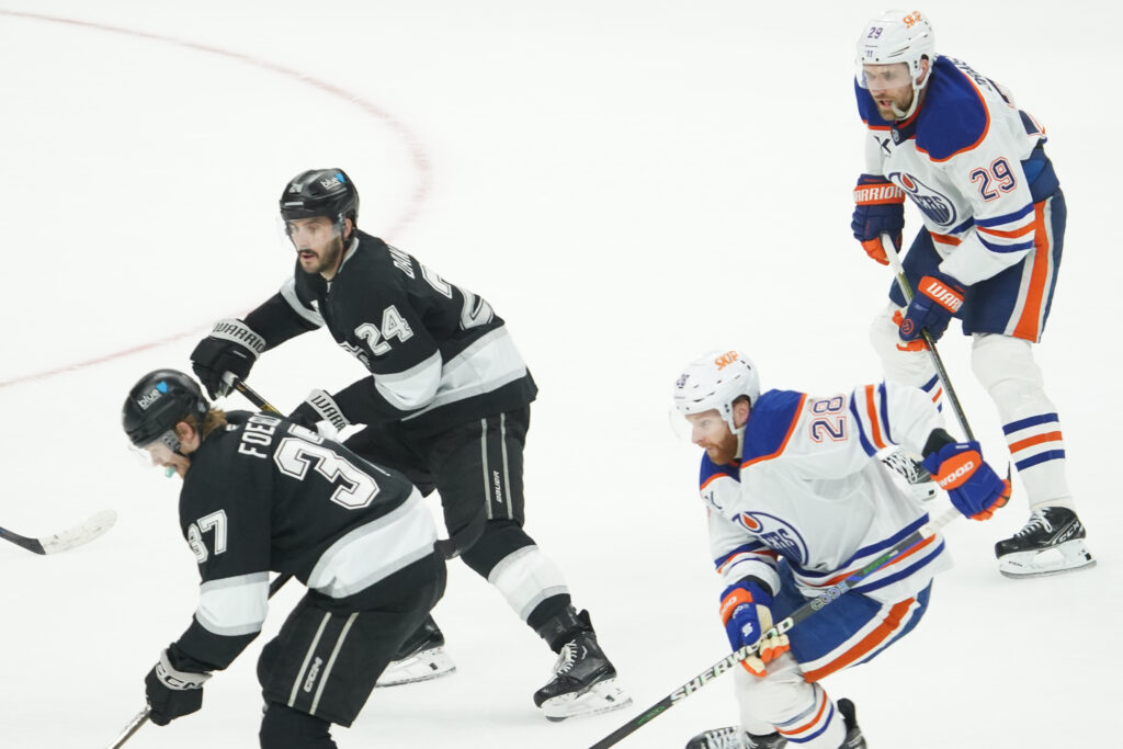 Hockey players from two teams battle for control on the ice rink.