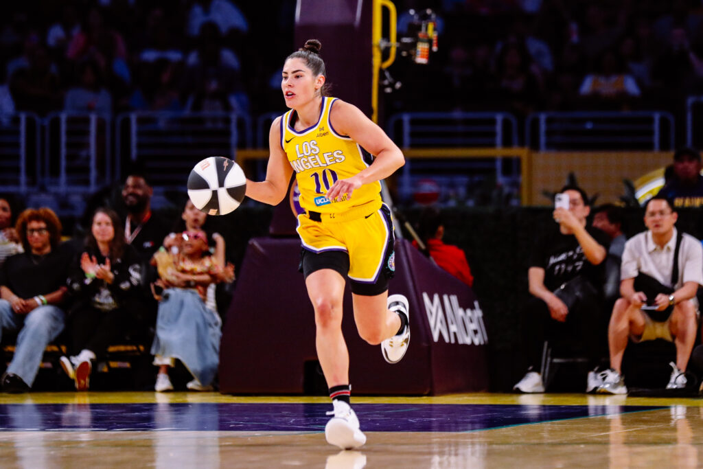 Los Angeles Sparks player #10 in yellow jersey running with basketball during game