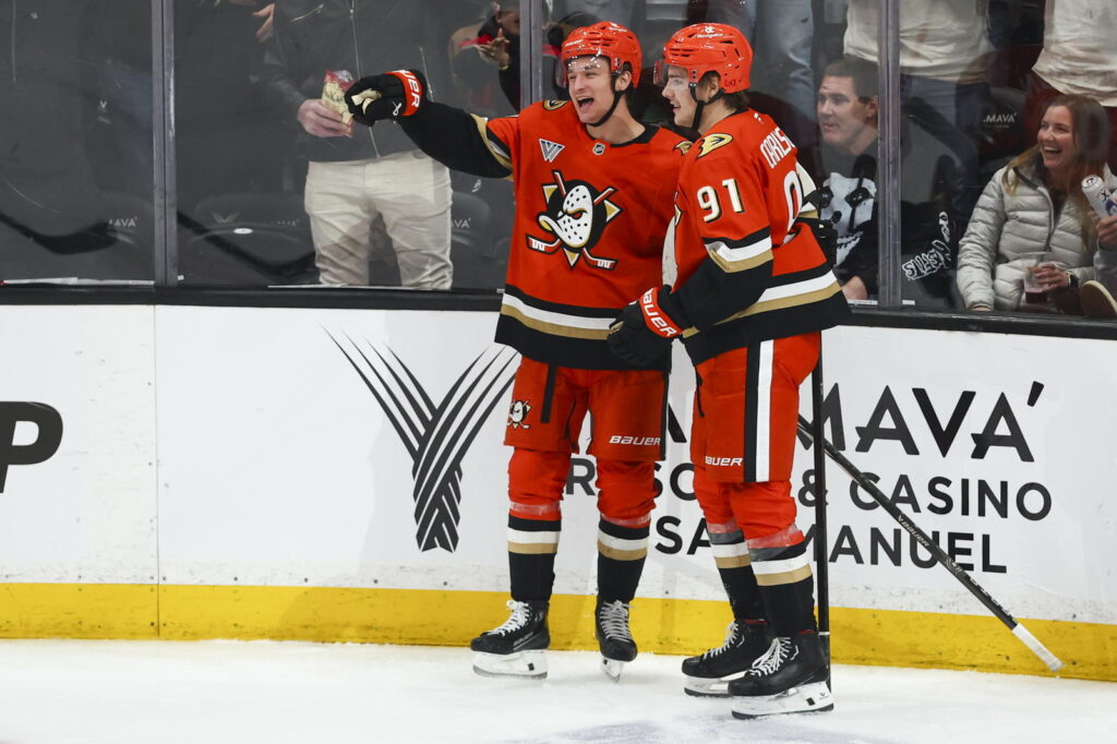 Two hockey players celebrating on the ice in red jerseys.
