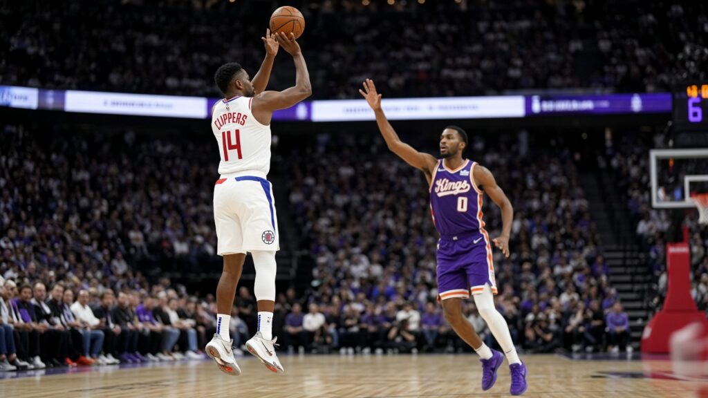 Clippers guard in white rises for a jump shot over a Sacramento Kings defender